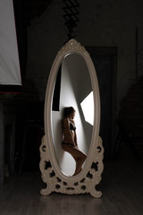 The reflection in the mirror standing at the wall of girls in underwear, backstage from studio shooting