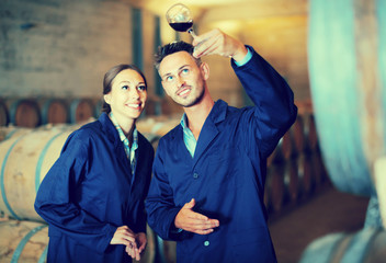 two winery employees with glass of wine.