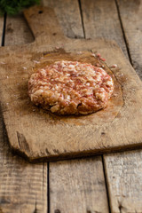 Raw minced meat in the form of cutlets (round and flat) on the chalkboard