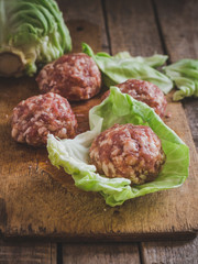 Cabbage rolls - minced meat in the form of balls and cabbage leaves on the kitchen board