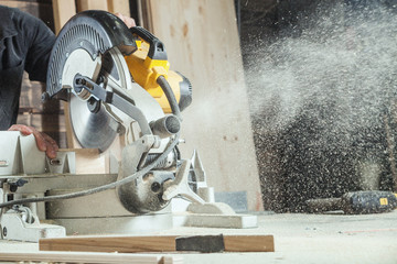 A close-up like a working circular saw cuts a board, sawdust flies to the sides