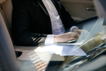 Businessman typing in a car
