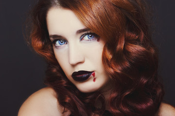 Pretty female fashion model posing in studio with dark gothic make up