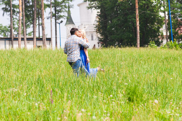 Naklejka na ściany i meble Happy young couple kissing in a summer park. Love concept. Vacation.