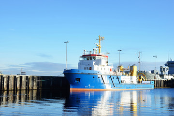 Moored tugboat and military ships on a pier in Hamburg