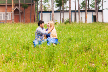 Happy young couple relaxing on the lawn in a summer park. Love concept. Vacation.