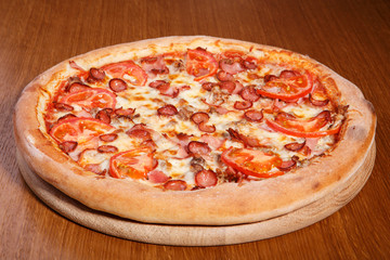 Italian pizza on the table, pepperoni, spices, tomatoes, cheese