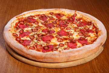 Italian pizza on the table, pepperoni, spices, tomatoes, cheese