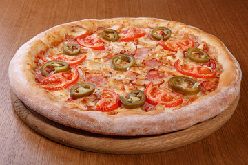 Italian pizza on the table, pepperoni, spices, tomatoes, cheese