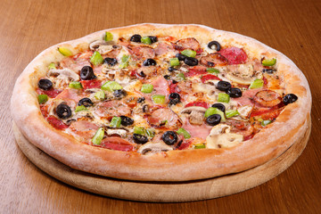 Italian pizza on the table, pepperoni, spices, tomatoes, cheese