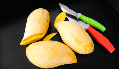 Ripe yellow mango on a black background