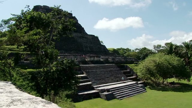 Tourist climbs up steps of temple El Castillo at Xunantunich archaeological site in Belize