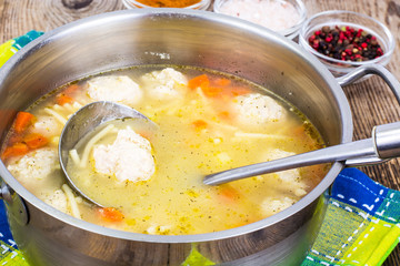 Soup with meatballs in metal pan
