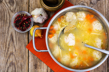 Soup with meatballs in metal pan