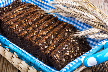 Black rye bread with cereal seeds on white background