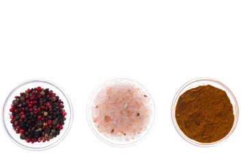 Salt, black pepper and curry in glass isolated on white backgrou