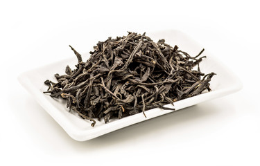 zheng shan xiao zhong black tea leaves on the rectangular white plate on the white background