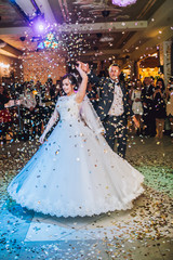 First wedding dance of newlywed. Confetti around.