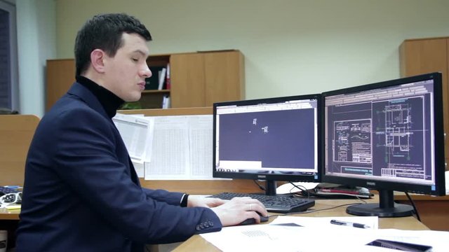 man making blueprints on computer. with two monitors