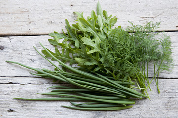 bunch of fresh onion, arugula and dill on the old wood