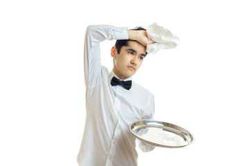 tired of the young waiter with tray put his hand with a napkin on his head