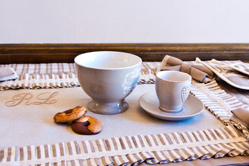 Elegant table set for breakfast with milk, coffee and biscuits With the morning light coming in from the window
