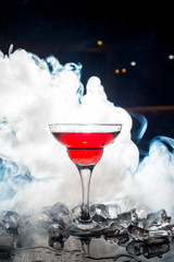 red cocktail with ice vapor, blue background