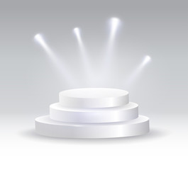 Round podium illuminated by spotlights.