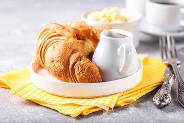Breakfast - croissant, egg and coffee. Selective focus.