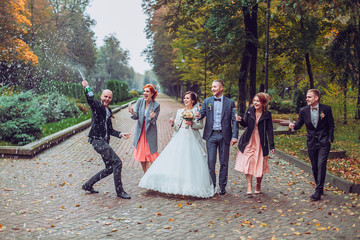 bride and groom with happy groomsmen and bridesmaids having fun and popping champagne, hilarious...