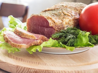 Slices of bacon and fresh lettuce and tomatoes on a wooden board. Selective focus.