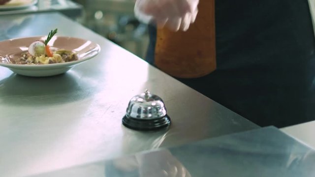 Chef of the restaurant serves a dish and calls the bell. 4k