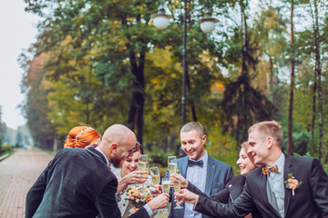 bride and groom with happy groomsmen and bridesmaids having fun and popping champagne, hilarious...