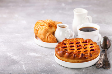 Breakfast - croissant, jam pie and coffee. Selective focus. Copy space.