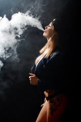 Beautiful girl vaping from e-cigarette.