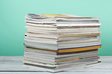 Open stacking book, magazine hardback colorful books on wooden table and green background. Back to school. Copy space for text. Education business concept.