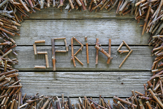 The inscription spring with wooden sticks on wooden background.