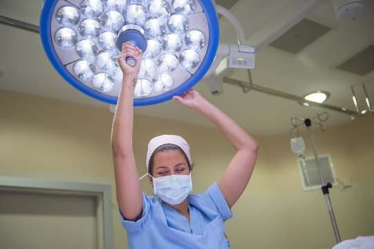 Nurse adjusting surgical light in operation room