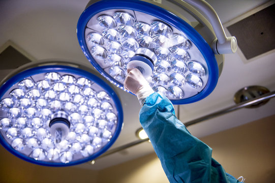 Unrecognizable doctor adjusting surgical light in operation room