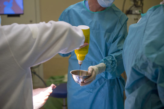 Medics pouring antiseptic to bowl