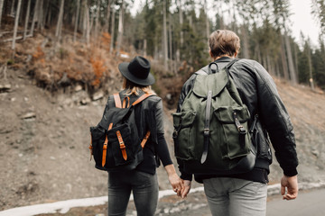 the couple are traveling. Boy and girl with backpacks travel. The couple walks along the path....