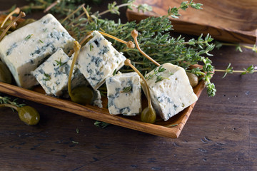Blue cheese , capers and branches of thyme .