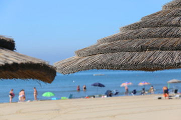 Fototapeta premium straw beach parasol to shelter from the hot summer sun in the lu