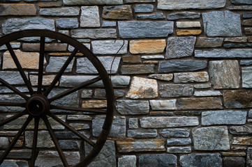 Stone wall pattern with rustic cart wheel