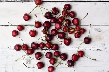 Naklejka na ściany i meble Fresh Cherry's spread on white wooden background 