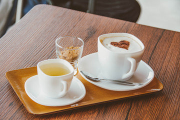 above view of coffee latte art, sugar on glass and tea cup on wooden table.