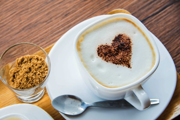 above view of coffee latte art, sugar on glass and tea cup on wooden table.