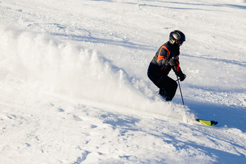 Skier mountain skiing riding on track slope. Concept active rest in winter, photo in motion, snow is scattered. Sheregesh ski resort