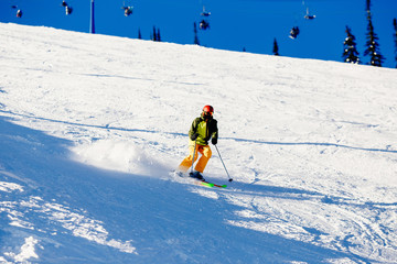 Fototapeta na wymiar Skier mountain skiing riding on track slope. Concept active rest in winter, photo in motion, snow is scattered. Sheregesh ski resort