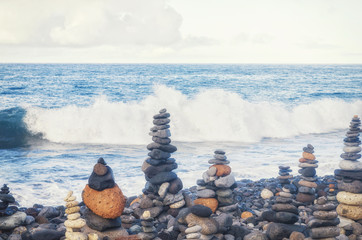 Concept of harmony and balance. Balance stones opposite the Atlantic ocean waves. Rock zen in the form of scales. Many balancing pebbles Stones Stacks. Canary islands, Tenerife, Adeje, Playa Del Duque